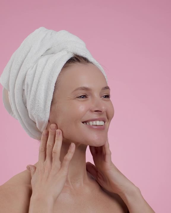 Smiling woman gently pressing her hands to her face